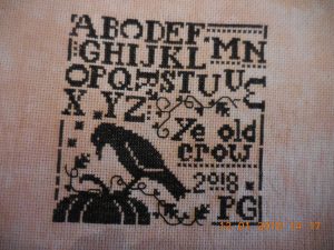 ye old crow sampler stitched piece.